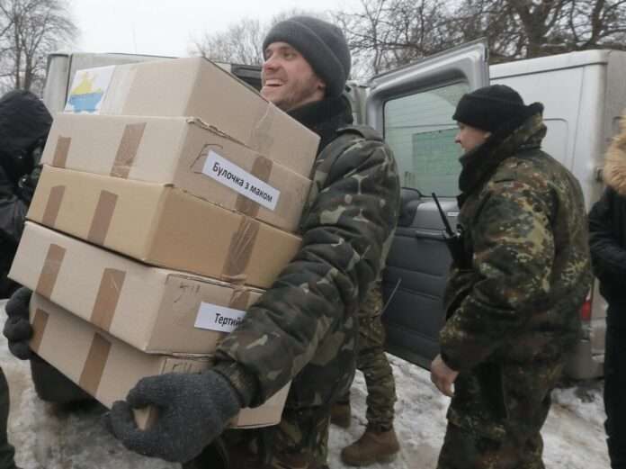 Ukrainian army soldiers unload a car with Christmas food